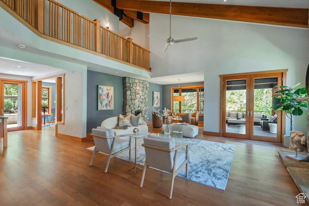 Living room featuring high vaulted ceiling, french doors, a healthy amount of sunlight, and hardwood / wood-style flooring