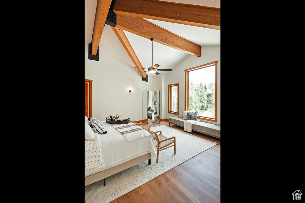 Bedroom with beamed ceiling, ceiling fan, high vaulted ceiling, and wood-type flooring