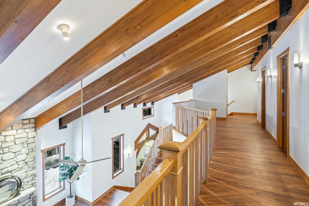 Hall featuring lofted ceiling with beams and hardwood / wood-style flooring
