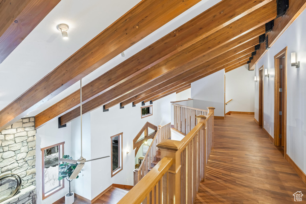 Hall featuring vaulted ceiling with beams and dark hardwood / wood-style floors