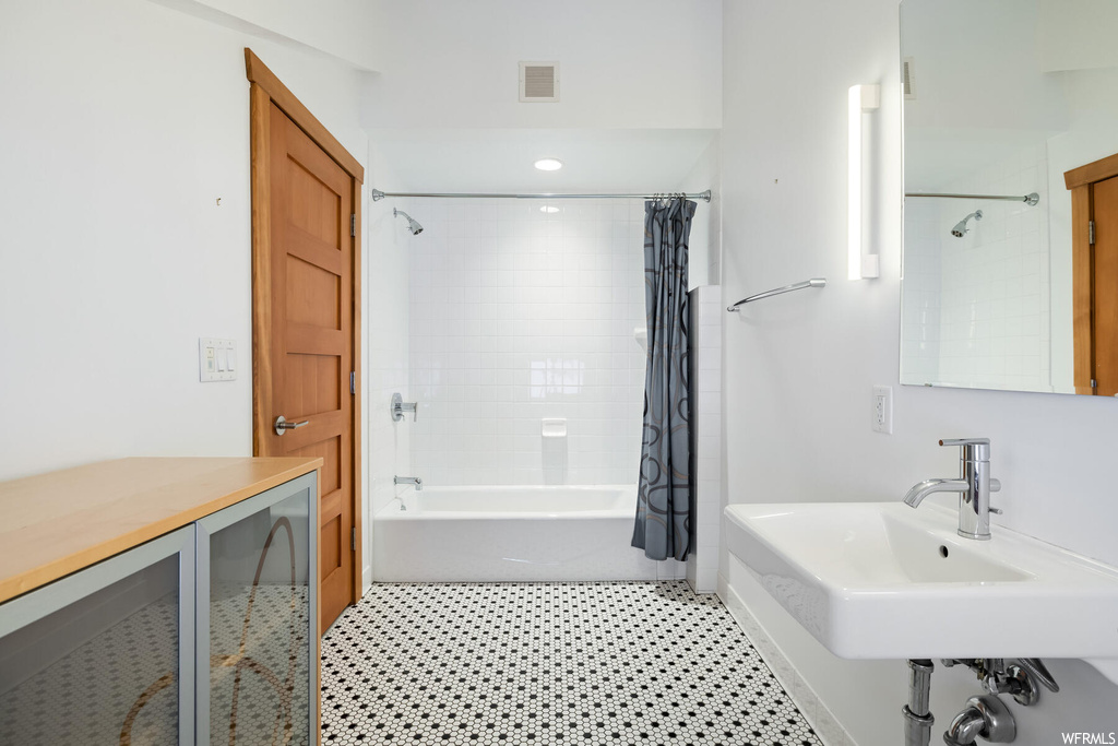 Bathroom with shower / tub combo, sink, and tile flooring