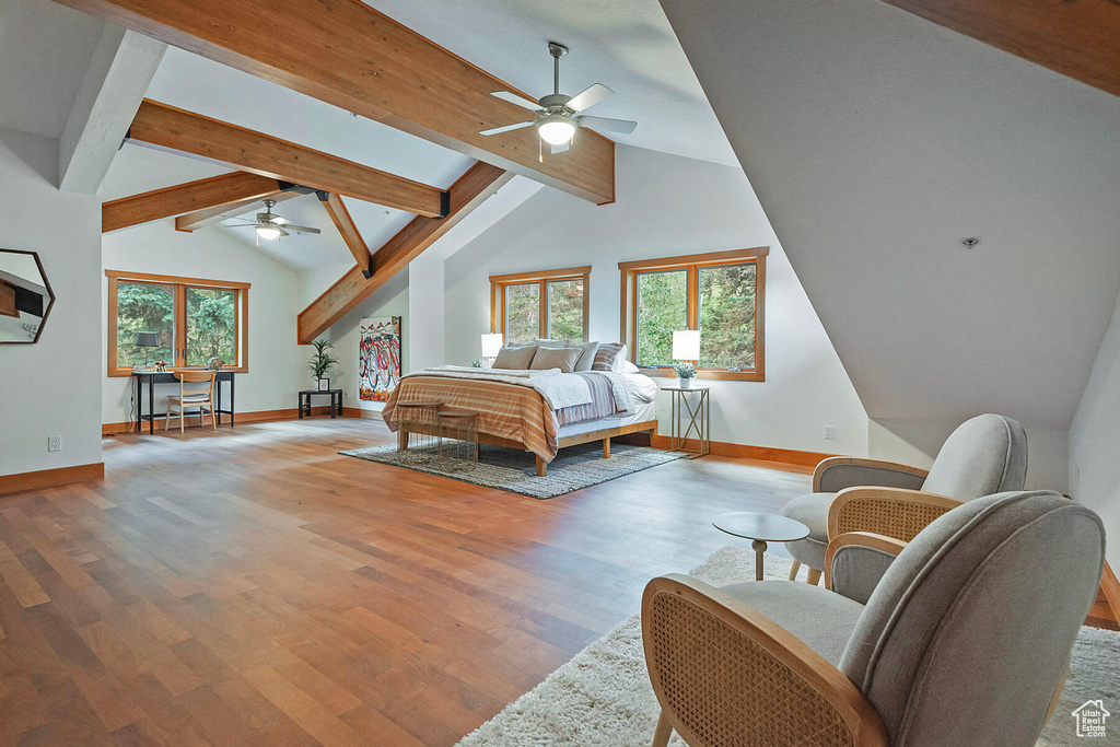 Bedroom featuring beamed ceiling, multiple windows, high vaulted ceiling, and wood-type flooring