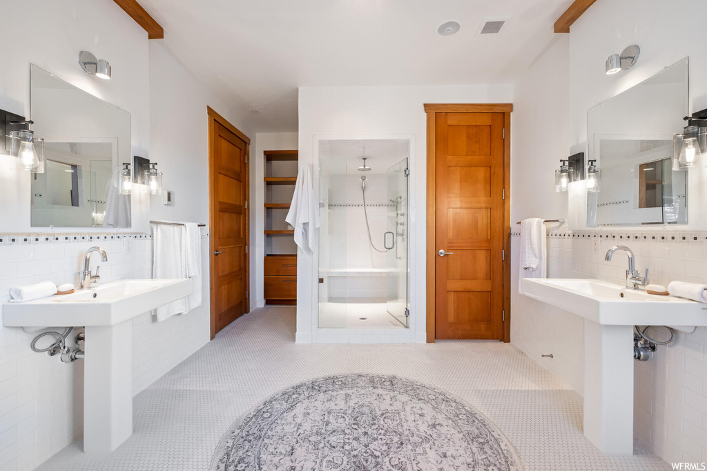 Bathroom featuring tile flooring, tile walls, walk in shower, and backsplash