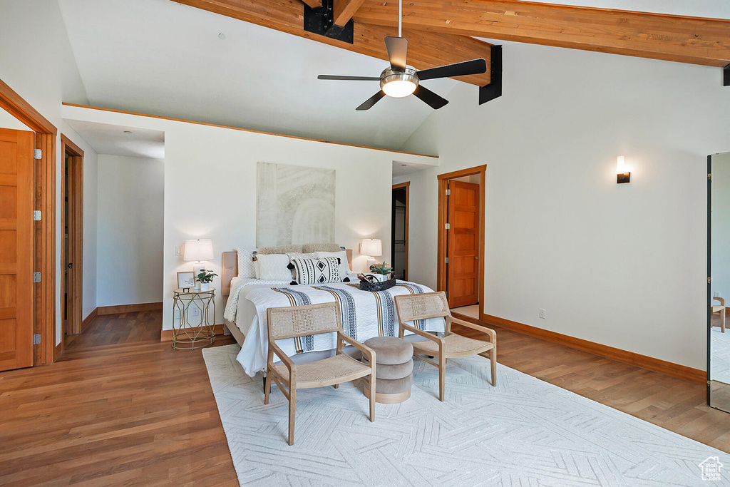 Bedroom with beamed ceiling, high vaulted ceiling, wood-type flooring, and ceiling fan