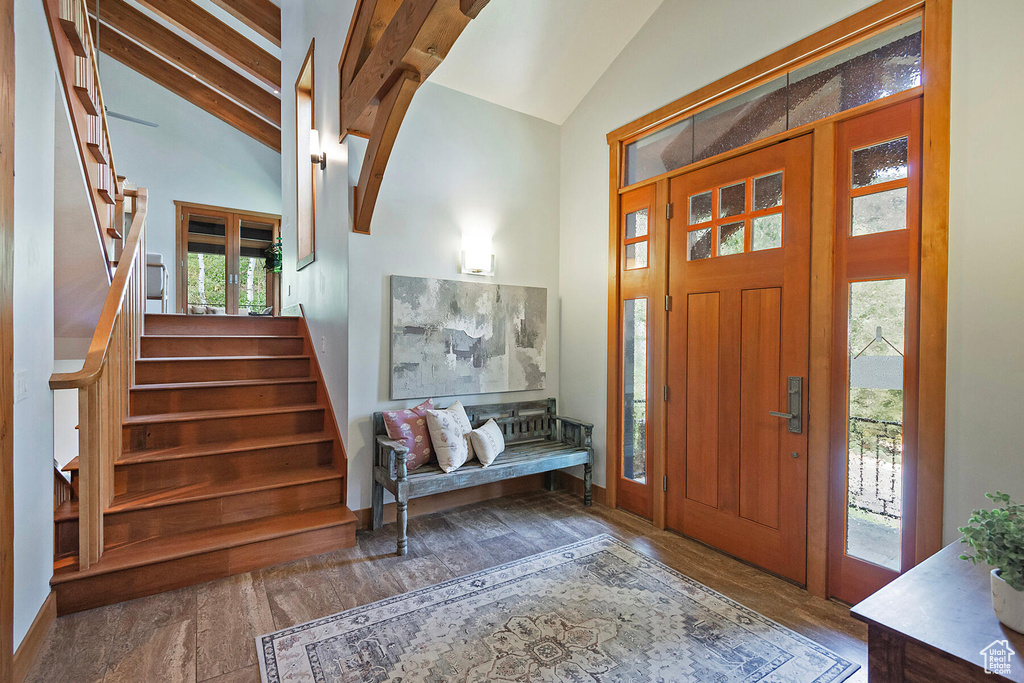 Entrance foyer featuring high vaulted ceiling, beam ceiling, and hardwood / wood-style flooring