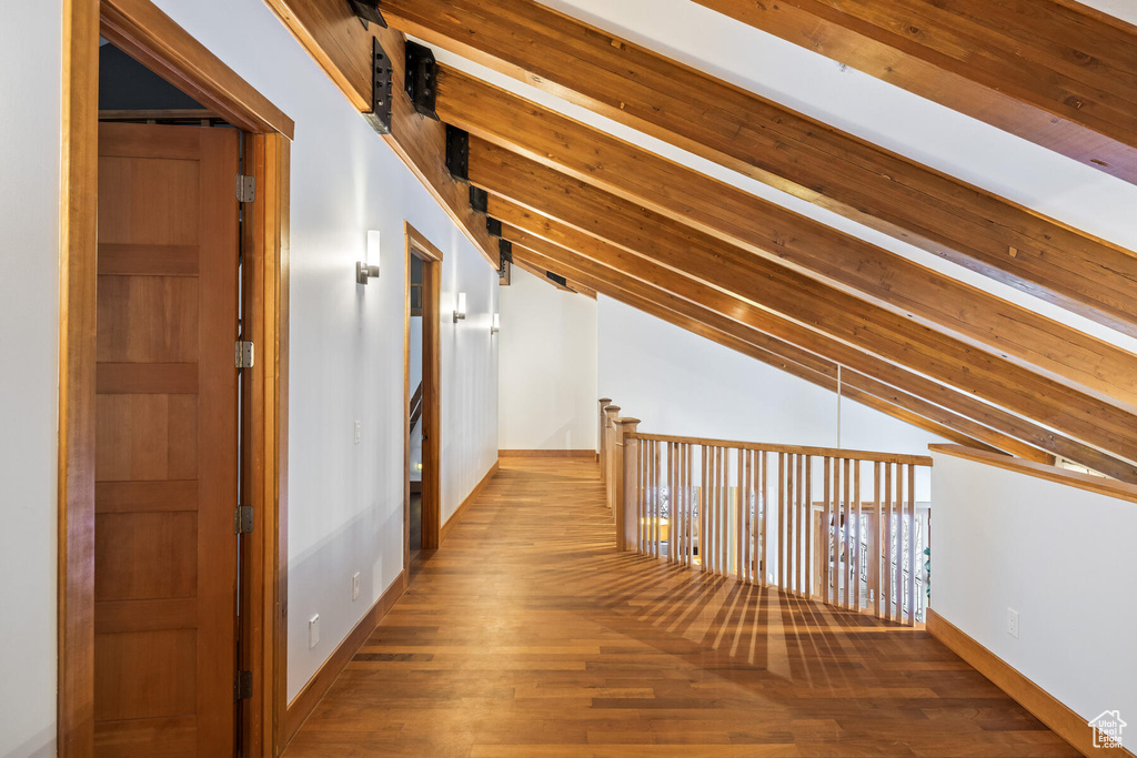 Hall with lofted ceiling with beams and hardwood / wood-style flooring