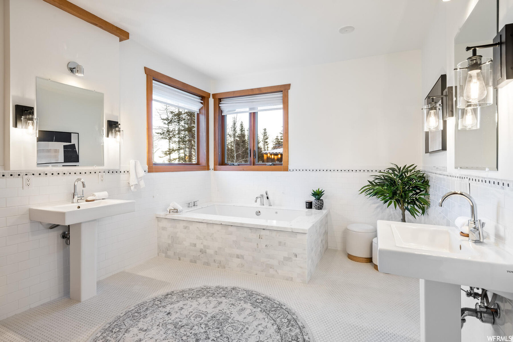 Bathroom with tile flooring, tile walls, tasteful backsplash, and a relaxing tiled bath