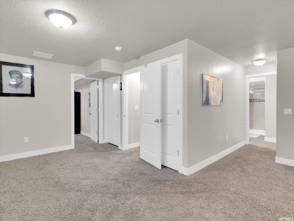 Interior space with light carpet and a textured ceiling