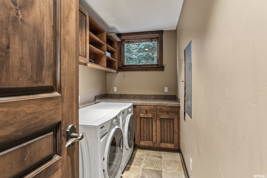 Washroom featuring independent washer and dryer, cabinets, and light tile floors