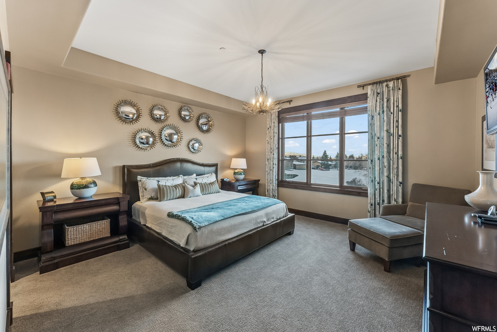 Bedroom with carpet floors, an inviting chandelier, and a water view