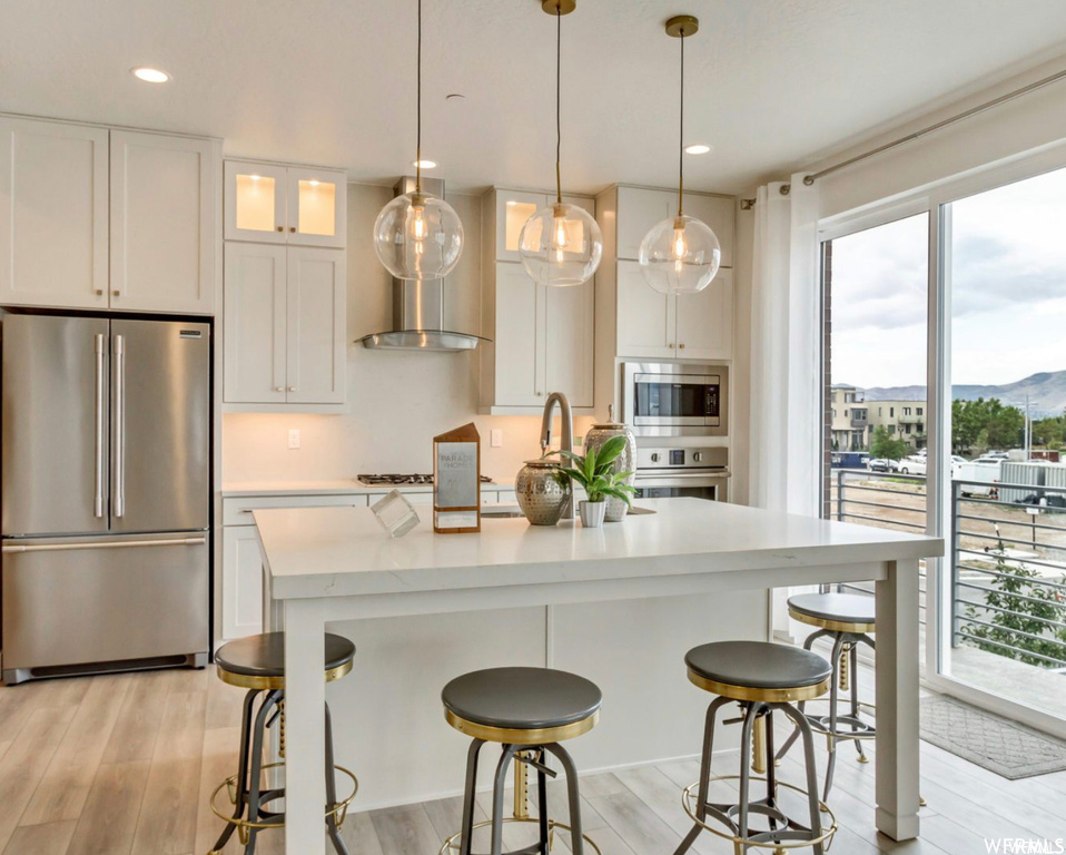 Kitchen with a wealth of natural light, appliances with stainless steel finishes, and white cabinetry