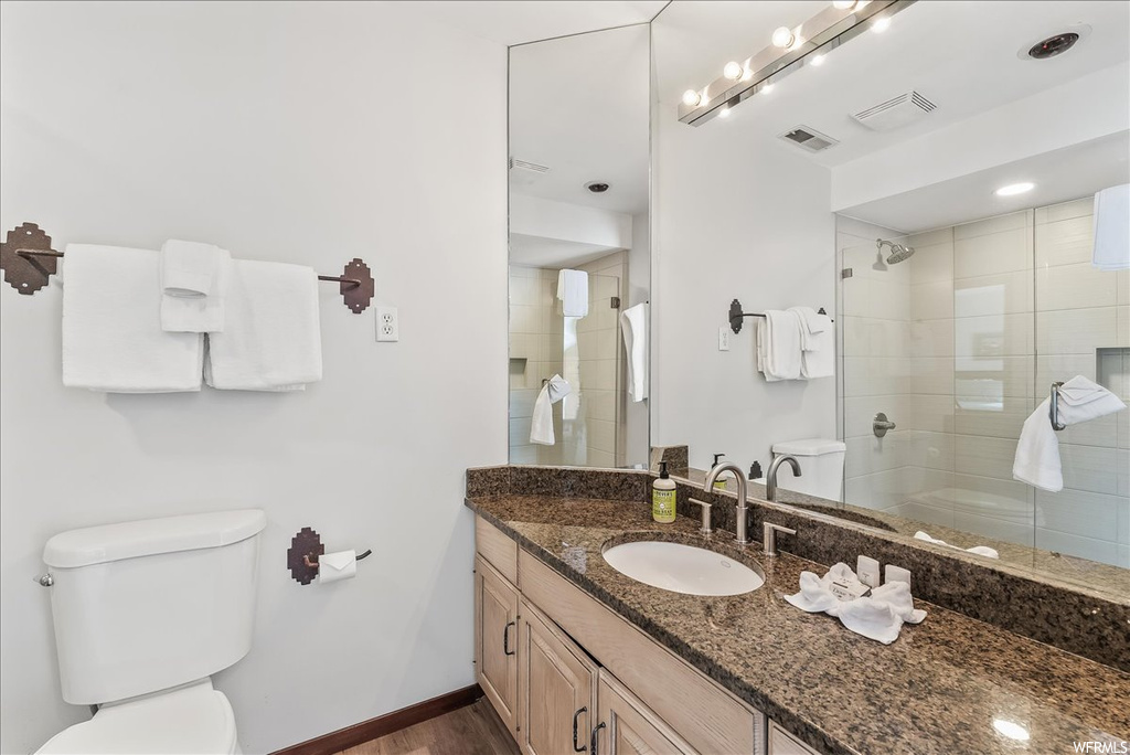 Bathroom featuring toilet, an enclosed shower, hardwood / wood-style floors, and vanity
