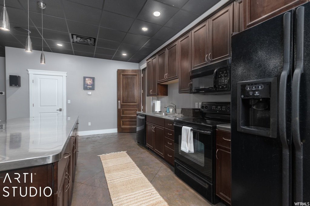 Kitchen featuring black appliances, a paneled ceiling, dark brown cabinets, and sink