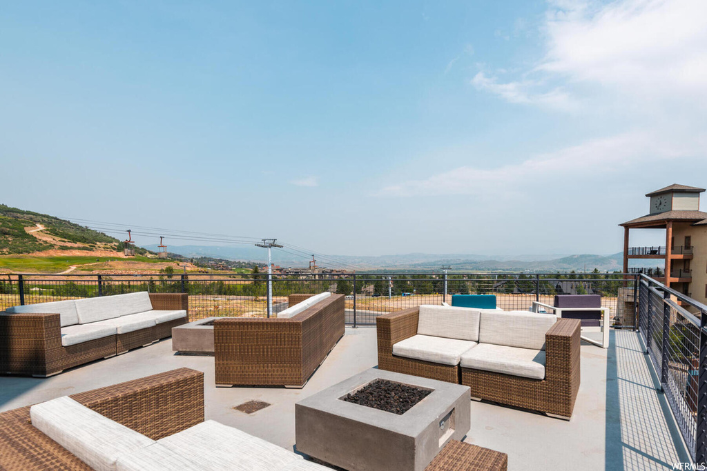 View of terrace featuring an outdoor living space with a fire pit and a mountain view