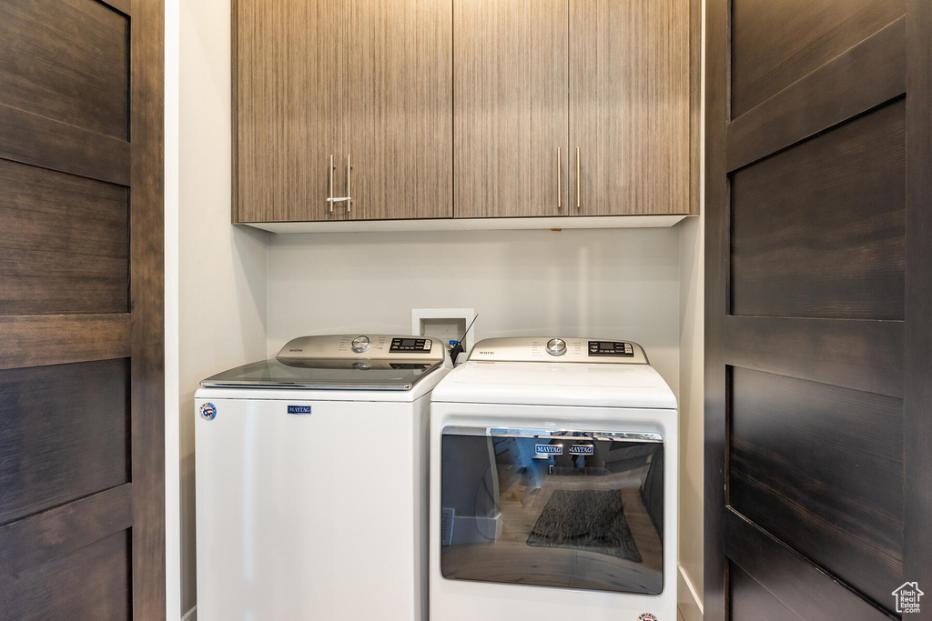 Clothes washing area featuring cabinets, separate washer and dryer, and washer hookup