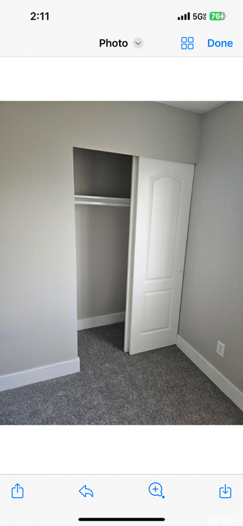 Interior space with dark carpet and a closet