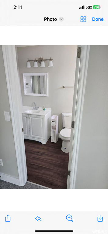 Bathroom with toilet, hardwood / wood-style floors, and sink
