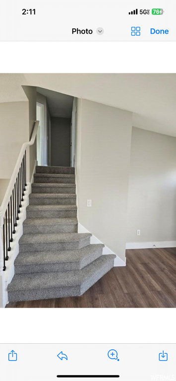 Staircase with dark hardwood / wood-style floors