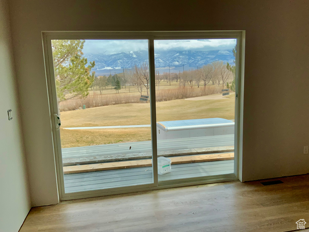 Doorway to outside featuring a mountain view and light hardwood / wood-style floors