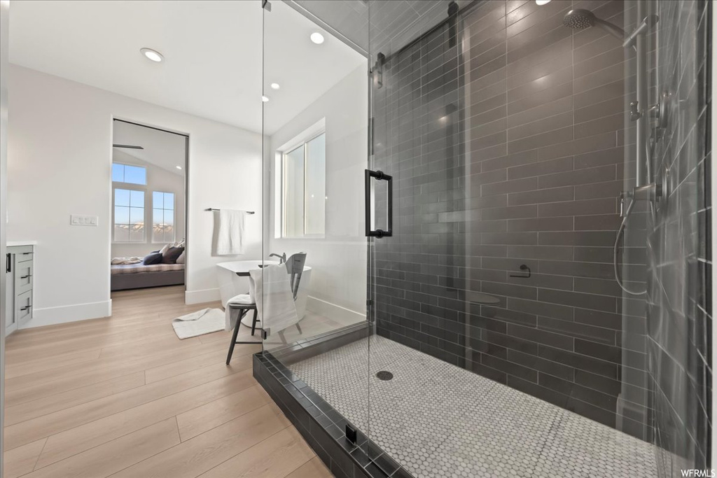 Bathroom with walk in shower, wood-type flooring, and vanity