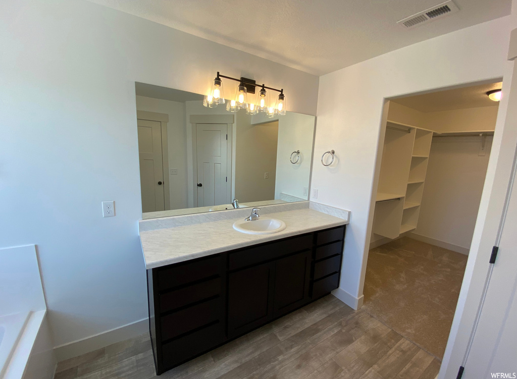 Bathroom featuring vanity, hardwood / wood-style floors, and a bathing tub