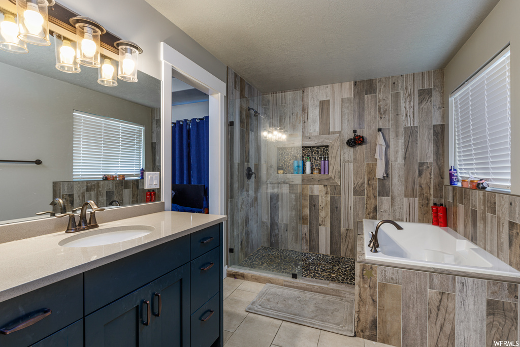 Bathroom with separate shower and tub, vanity, and tile flooring