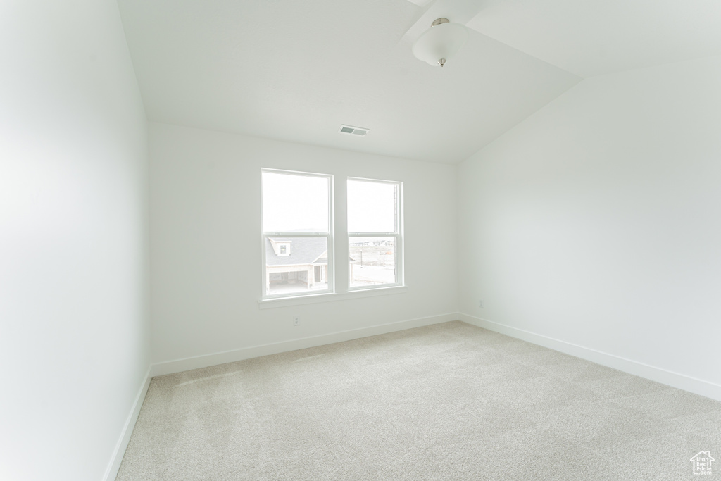 Spare room with lofted ceiling and light colored carpet