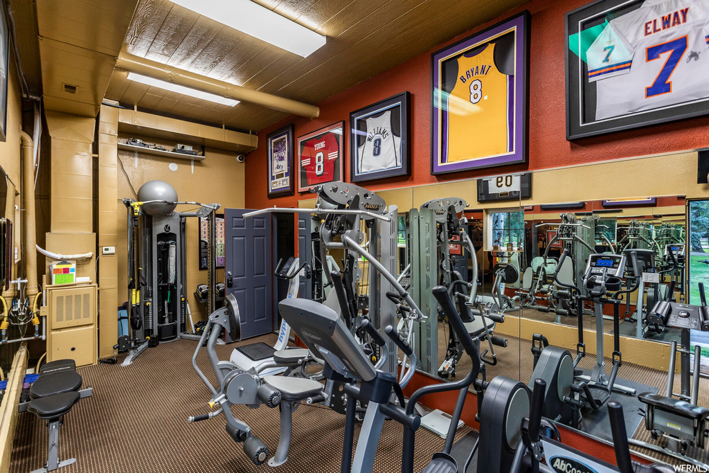Workout area with wood ceiling and dark colored carpet