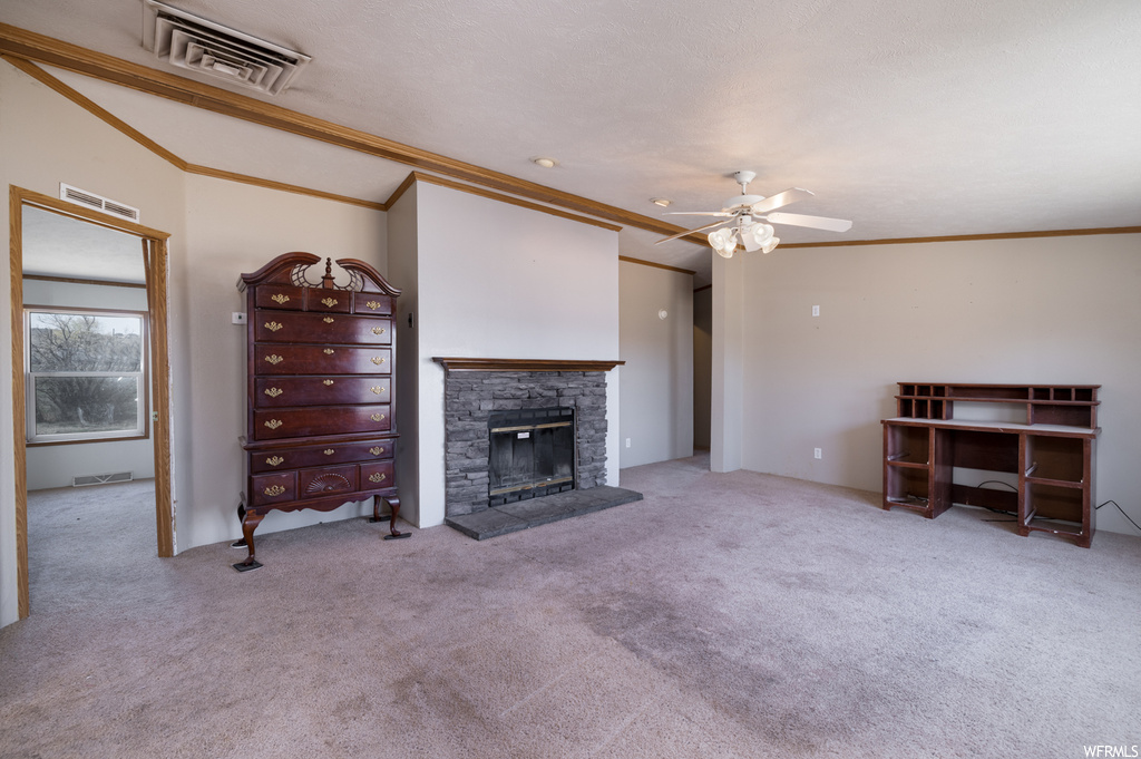 Living room with a fireplace, crown molding, lofted ceiling, ceiling fan, and light carpet