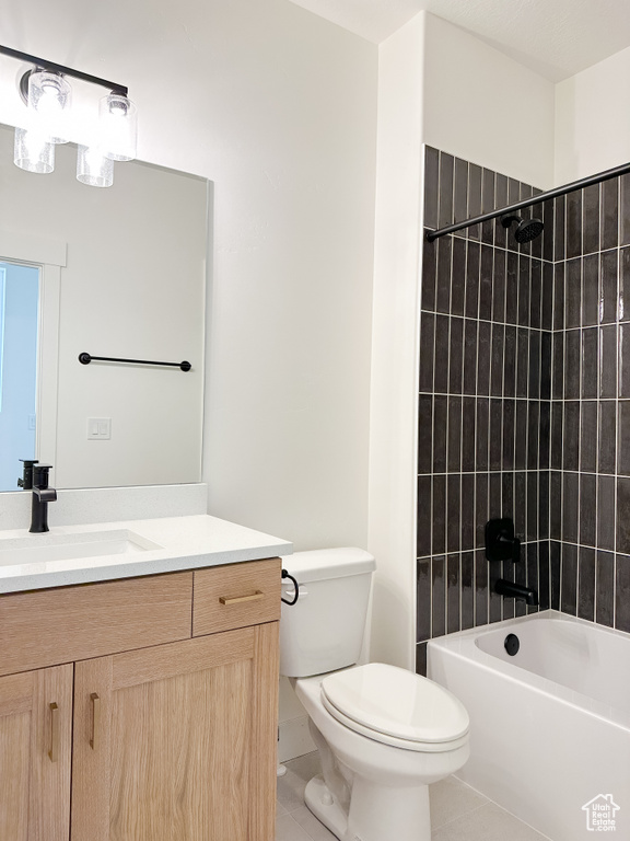 Full bathroom with tile floors, tiled shower / bath combo, toilet, and oversized vanity