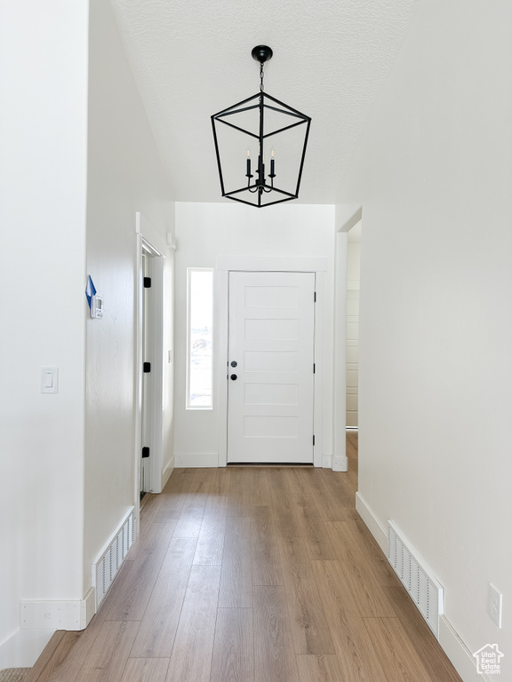 Entryway featuring an inviting chandelier and light wood-type flooring