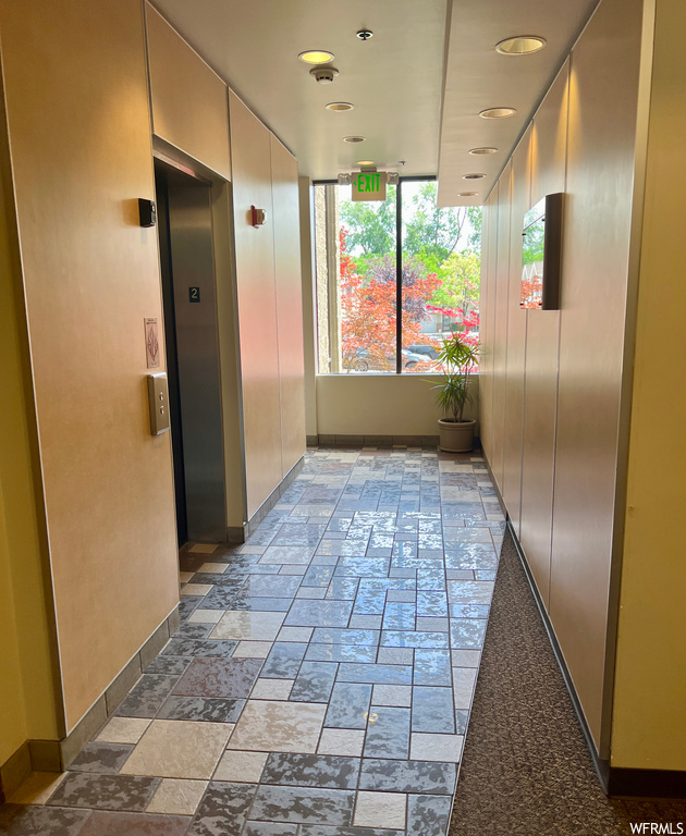 Corridor with elevator and light tile floors
