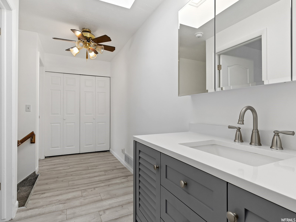 Bathroom with ceiling fan, hardwood / wood-style floors, and vanity