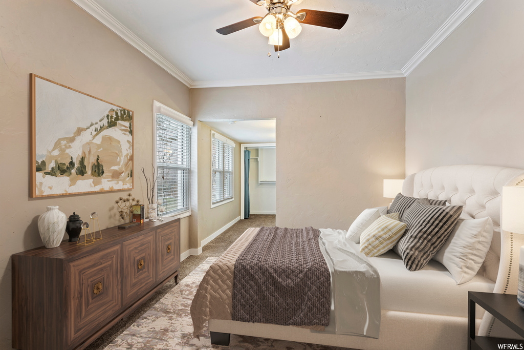 Bedroom with ornamental molding, ceiling fan, and carpet floors