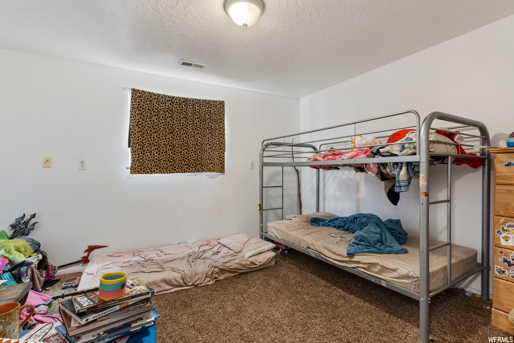 Carpeted bedroom with a textured ceiling