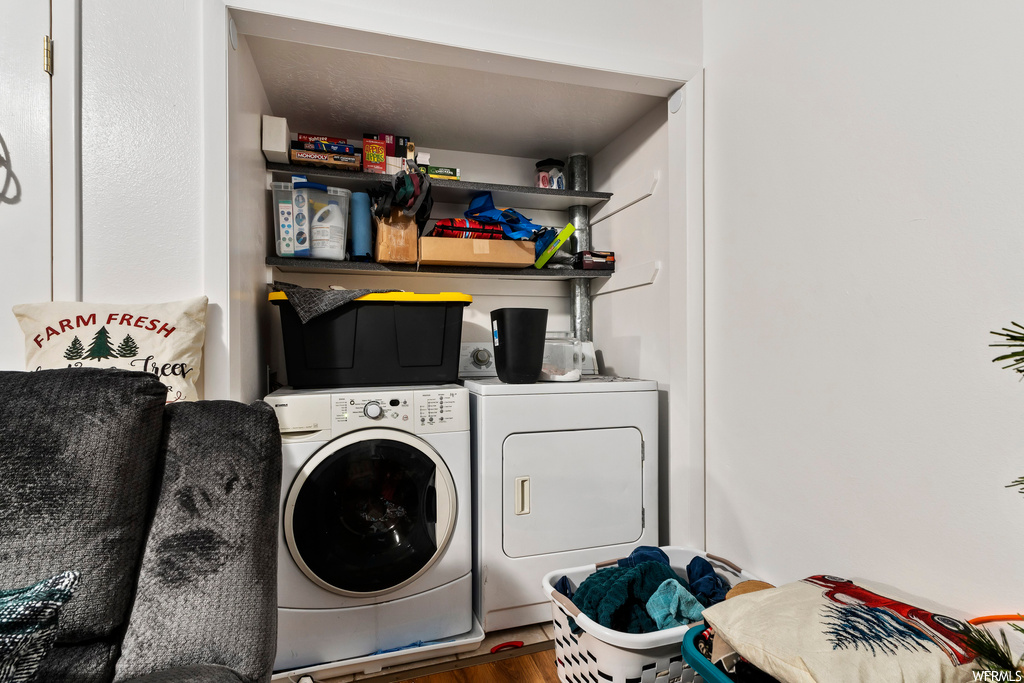 Laundry area featuring independent washer and dryer and wood-type flooring