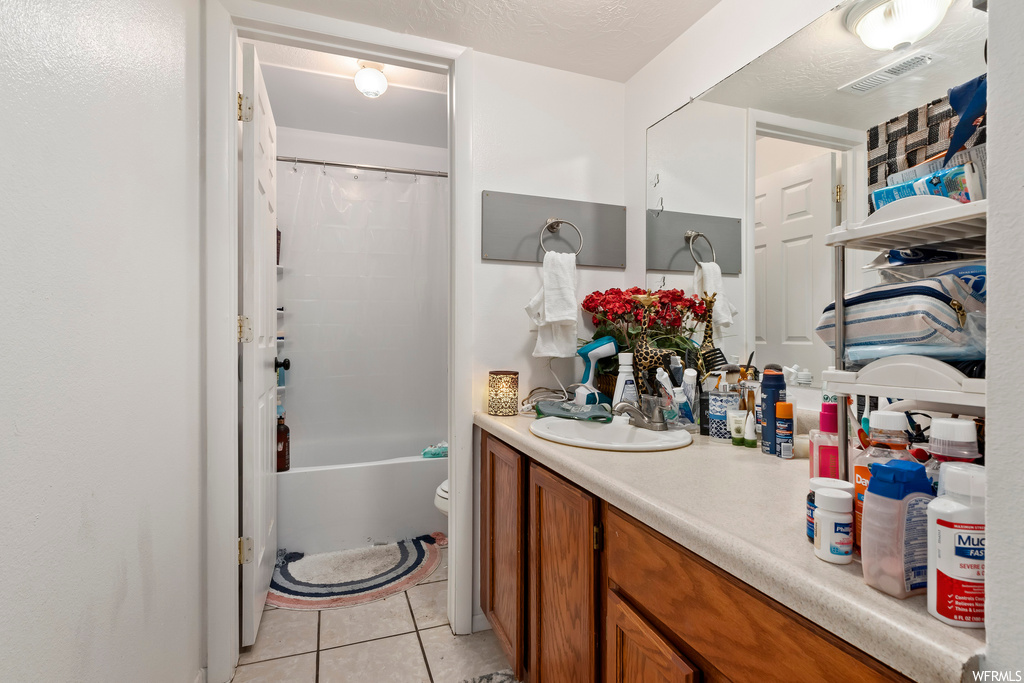 Full bathroom with toilet, tile flooring, shower / tub combo with curtain, and vanity