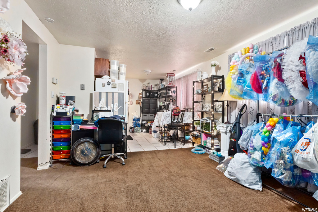 Interior space with light colored carpet and a textured ceiling