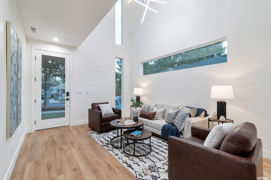 Living room featuring a high ceiling and light hardwood / wood-style floors