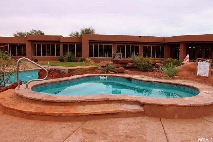 View of pool with an outdoor hot tub