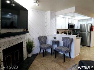 Kitchen with light tile flooring, white cabinets, and stainless steel appliances