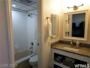 Full bathroom with toilet, shower / bathtub combination, and vanity with extensive cabinet space