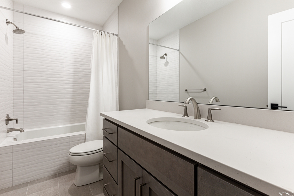 Full bathroom with shower / bathtub combination with curtain, tile floors, toilet, and vanity