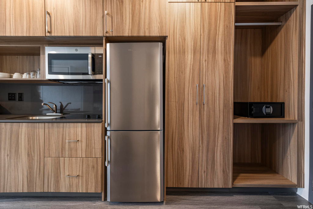 Kitchen with sink, dark wood-type flooring, and stainless steel appliances