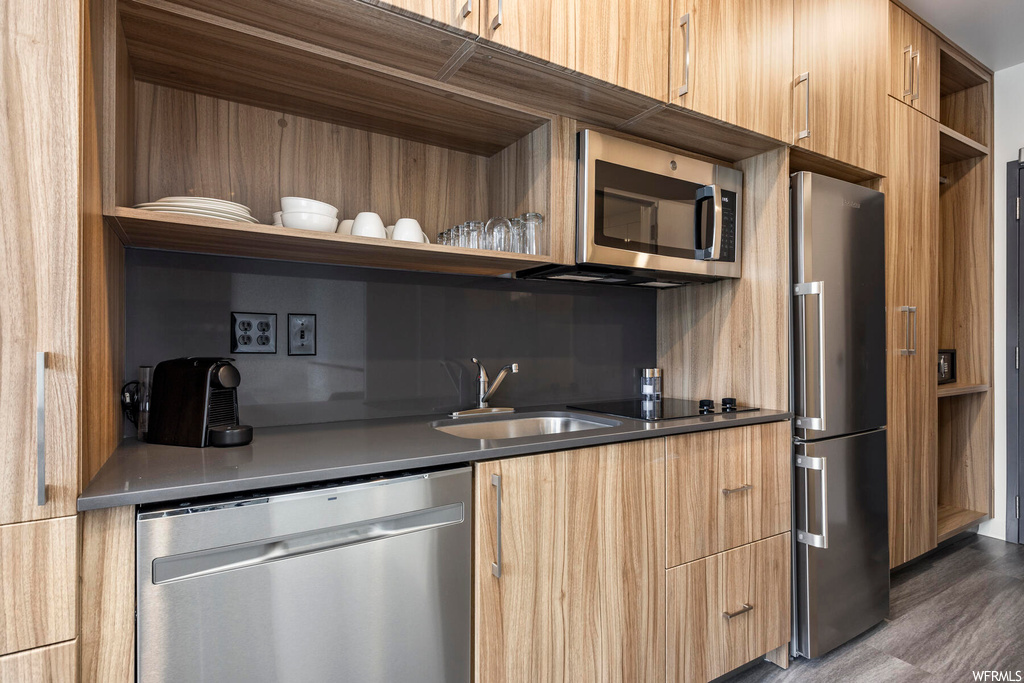 Kitchen with sink, appliances with stainless steel finishes, and dark wood-type flooring
