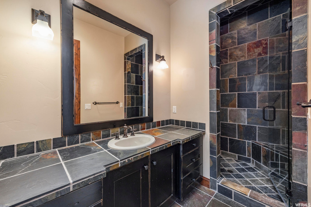 Bathroom with vanity, walk in shower, tasteful backsplash, and tile flooring