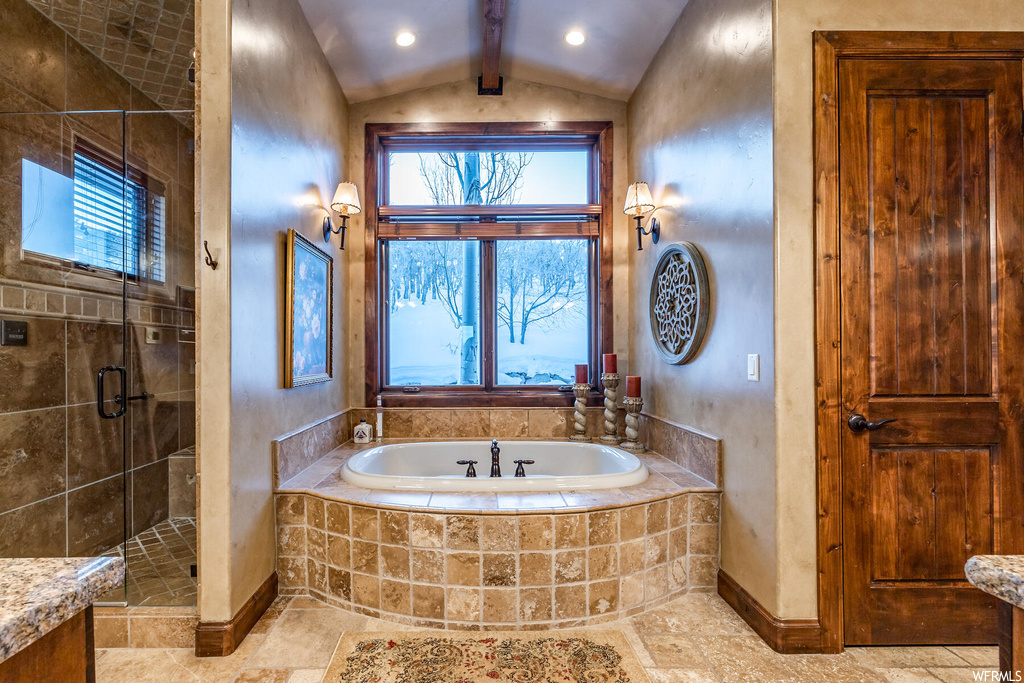 Bathroom with vaulted ceiling with beams, a wealth of natural light, and tile floors