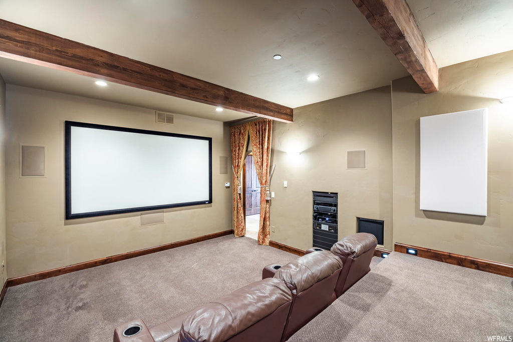 Home theater featuring carpet flooring and beamed ceiling