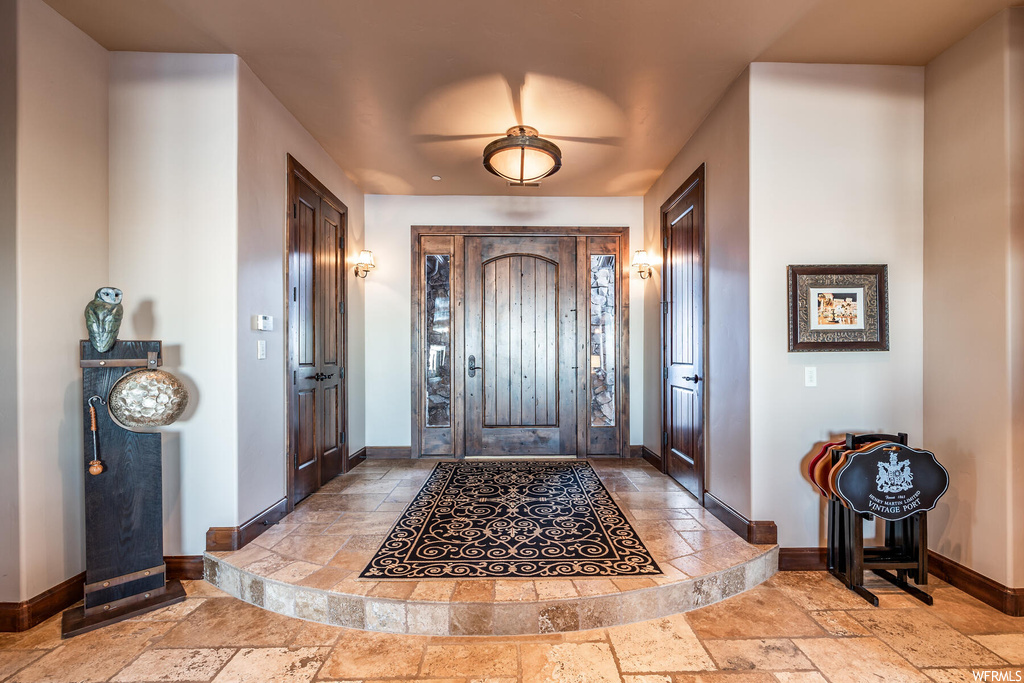 Foyer featuring light tile flooring and ceiling fan
