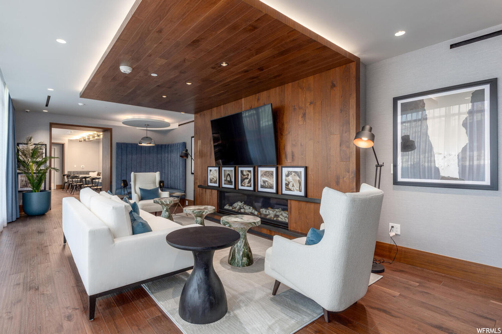 Living room with dark hardwood / wood-style flooring and wood walls